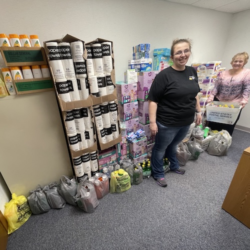 staff members stand with non-pantry supplies