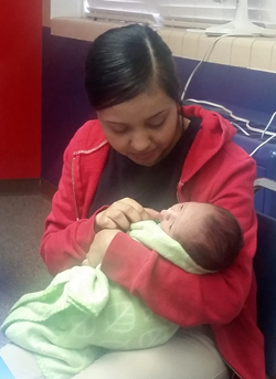 Teen Mom participant sits with her new baby.